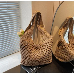 Detail of hand-woven straw hobo bag showing intricate hollow-out texture and natural fiber