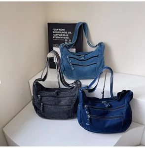 Three denim hobo bags in light blue, dark blue, and vintage grey with zip pockets