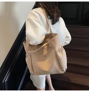 Detailed side view of khaki canvas tote bag with drawstring pockets on stone stairs