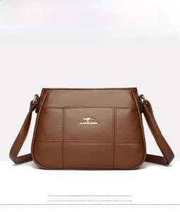 Front view of coffee brown crossbody bag with quilted texture and metal logo detail
