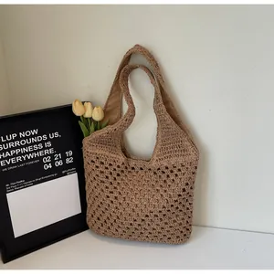 Detail of hand-woven straw tote bag with intricate hollow-out pattern and inner lining