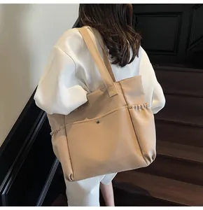 Detail view of beige nylon crossbody bag with snap pocket and adjustable side pockets