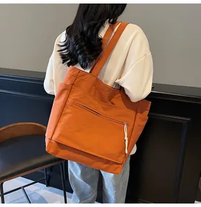 Vue arrière du grand cabas en toile orange avec poches latérales porté par un mannequin