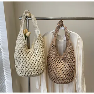 Detail of hollow paper rope woven tote bag with knot handles in beige and light brown