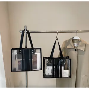 Détail du cabas transparent en PVC avec bordures en similicuir noir et rayures fines