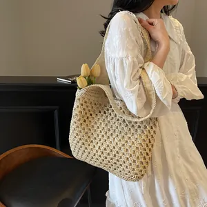 Summer hand-woven straw tote bag with hollow knit design and beige fabric lining for beach