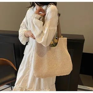 Beige woven tote bag with large capacity shown being worn by a model in a vintage setting