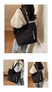 Détail du grand sac cabas en toile noire avec fermeture éclair à pompon blanc élégant