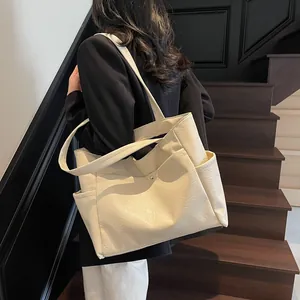 Minimalist large off-white tote bag in textured leather shown on model for daily commuting