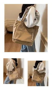 Détail du sac fourre-tout en toile kaki avec poche zippée et compartiment latéral