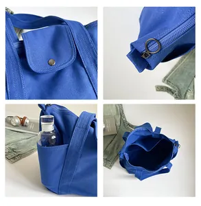 Detail view of Klein blue canvas tote bag showing zip closure, front pocket and interior storage