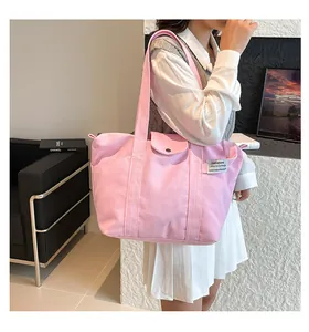 Detailed view of pink canvas tote bag showing the magnetic snap button and woven label
