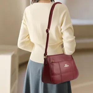 Burgundy faux leather crossbody bag for middle-aged women with kangaroo logo and stitching