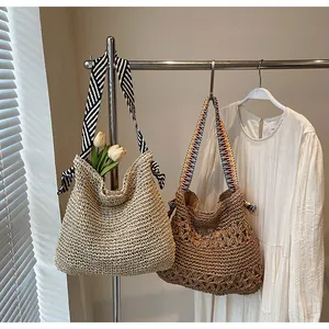 Detail of white and brown woven straw tote bags with patterned ethnic shoulder straps