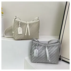 Detailansicht geflochtener Tragetaschen in Creme und Silber mit feinen Schultergurten
