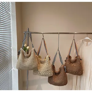 Detailed view of handmade woven straw tote bags with patterned bohemian shoulder straps