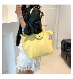 Close-up of bright yellow canvas tote bag with functional buckled front pocket
