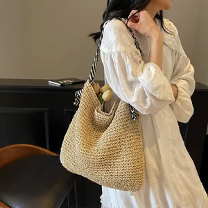 Straw tote bag with striped fabric handles for beach vacations and summer travel