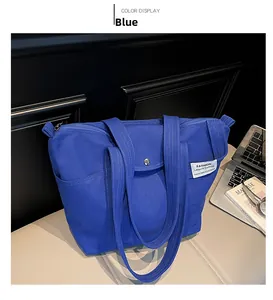 Detail of royal blue canvas tote bag showing side pocket and white woven label