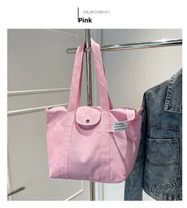 Pink canvas tote bag featuring front snap pocket and casual shoulder strap design