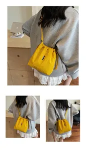 Detalle del bolso saco amarillo con cordón que muestra el logo y la tela de nylon
