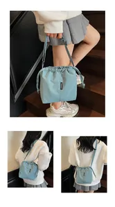 Detalle del bolso tipo cubo de tela oxford azul claro con cordón y correa ajustable
