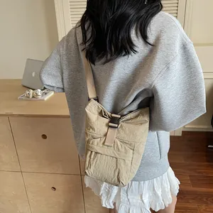 Bolso bandolera de nailon caqui con correa ajustable en vista trasera del modelo