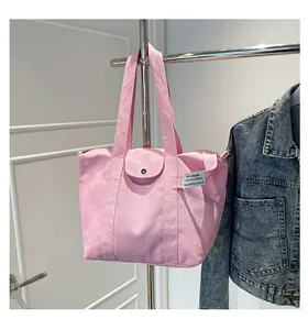 Detail of pink canvas tote bag showing thick fabric texture and metallic snap button
