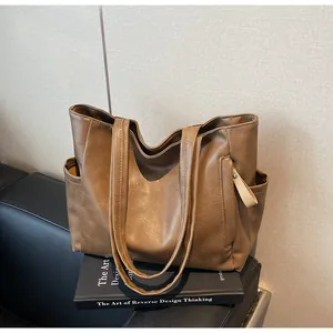 Close-up of textured leather tote bag showing side pockets and side strap details