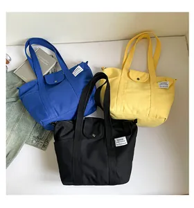 Flat lay of canvas tote bags in blue, yellow and black with leisure fashion labels