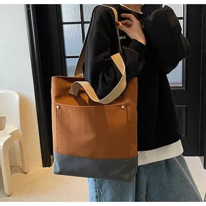 Detail view of contrast canvas tote bag with brown fabric and dark grey leather base