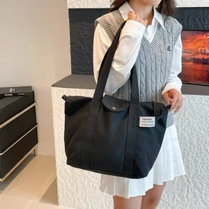 Large capacity black canvas tote bag for women featuring a minimalist fashion label