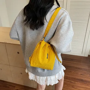 Bolso tipo cubo de lona amarillo brillante con cordón y correa de hombro para mujer