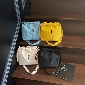 Bolsos tipo cubo con cordón en cuatro colores y correas de hombro ajustables
