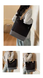 Macro detail of large canvas tote bag featuring contrast stitching and gold metal rivets