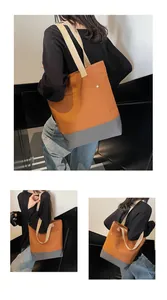 Detail view of large canvas tote bag with brown and grey contrast stitching and rivets