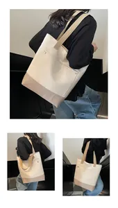 Detail of canvas tote bag showing contrast stitching, metal rivets and durable strap