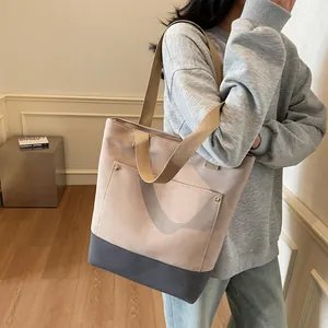 Minimalist color-block tote bag with front pocket and woven straps for daily commuting