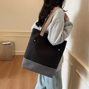 Minimalist black and grey canvas tote bag with contrast stitching and shoulder strap