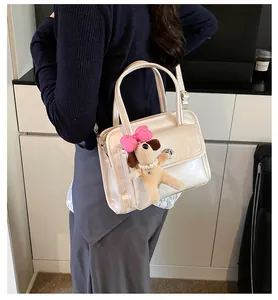 Detail of a creamy white bowling bag with metal lock and cute puppy plush pendant