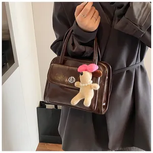 Detail of dark coffee brown leather bowling bag with vintage silver buckle and cute dog charm