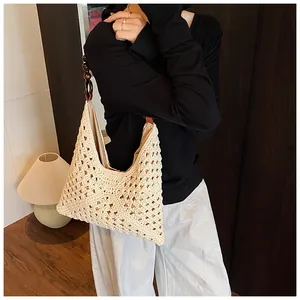 Detalle del bolso hobo tejido a mano con patrones de ganchillo y asas de cuentas de madera