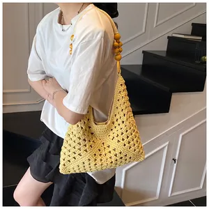 Detalle del bolso de hombro de ganchillo amarillo con cuentas de madera y aros únicos