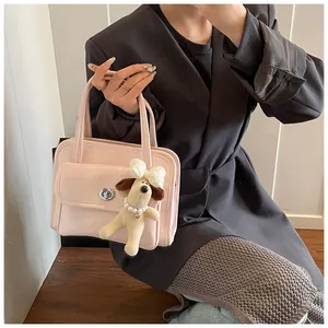 Detail of pink faux leather bowling bag featuring metal twist lock and cute plush puppy charm