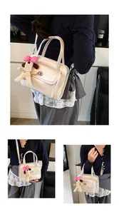 Detail of cream bowling bag with metallic twist lock and cute plush dog charm