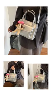Detailed view of silver metallic bowling bag with plush dog charm and twist lock pocket