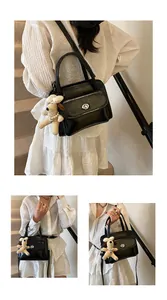 Close-up of black glossy bowling bag with silver lock and plush puppy charm detail