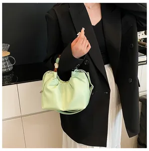Détail du sac nuage plissé vert menthe avec poignée perlée rétro et texture de litchi