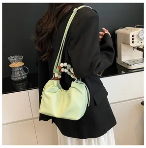 Détail du sac nuage plissé vert menthe avec poignée en perles colorées sur modèle