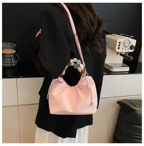 Sac nuage rose texture litchi avec poignée en perles colorées et bandoulière longue